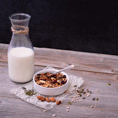 Granola Cereal with bottle of milk on wooden table