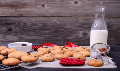 Home baked chocolate cookies on cooling rack with ingredients on