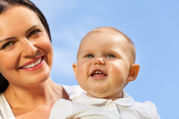 Close-up of cute baby and his mummy over sky