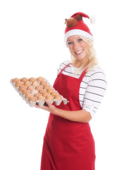 Frau mit Weihnachtsmütze hält eine Pappe mit rohen Eiern und lächelt
