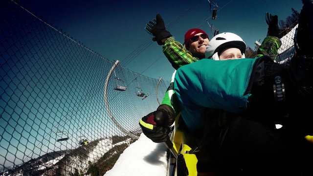 4K grunge styled Video: Father and son enjoying bobsleigh attraction