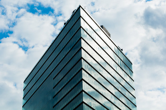 Office Building pointing up with clouds.