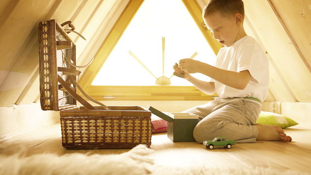 Bright yellow-sepia footage of a boy playing in his attic room