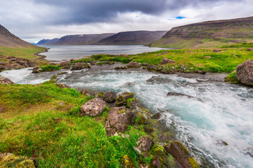 Obraz premium Mountain river flowing into the lake between the mountains in Iceland