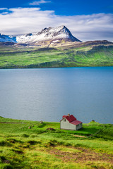 Small cottage in the mountains above the fjord in Iceland © shaiith