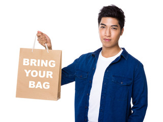 Man hold with shopping bag and showing phrase of bring your bag