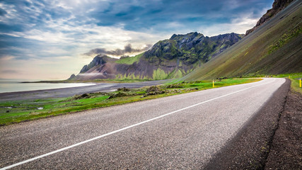 Road and volcanic mountains at the sea in Iceland