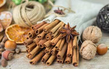 Fototapeta na wymiar Cinnamon sticks, star anise and nuts on an old wooden table