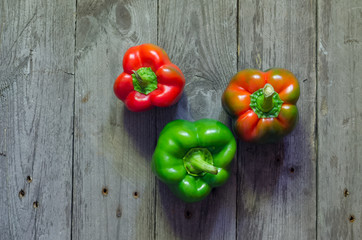 Green and red pepper on wooden background, selective focus