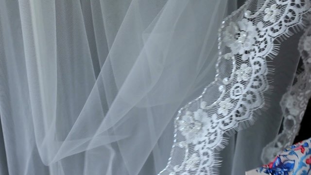 Lace in her hands. Girl hands stroked and touched the delicate lace fabric. The veil of the bride. Preparing for a wedding.