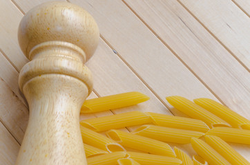 Pasta with salt caster on wooden background