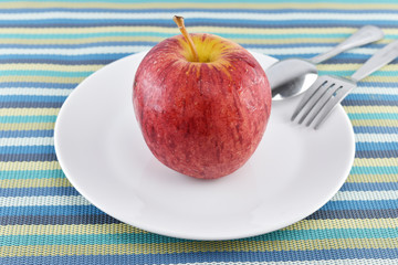 Green apple on dish concept for healthy diet and body weight con