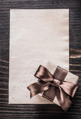 Giftbox paper on vintage wooden board vertical version