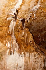 Stalactite and stalagmite formations on the wall of an undergrou
