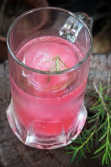 Raspberry flavour ice in soda water decorated with rosemary