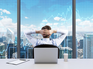 Rear view of the relaxing businessman with crossed hands behind his head, who is looking at NYC....