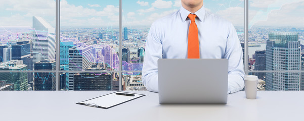 Young businessman is working with the laptop. Modern Panoramic office or work place with New York...