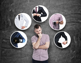 A handsome person in a casual shirt is thinking about different professions. Black chalkboard as a...