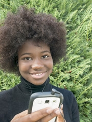 Afro girl listening to music in a park