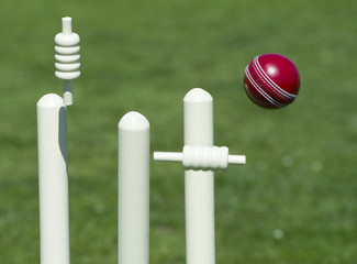 Bails fly in air after ball hits cricket stumps