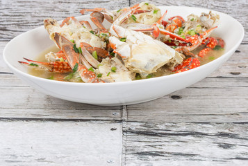Malaysian dish clear crab soup in an oblong plate over wooden background
