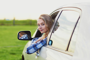 Beautiful young driver looking out of the car