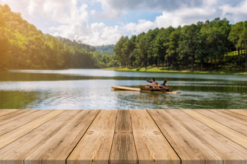 Wooden board empty table in front of blurred background. Perspective brown wood over blur lake in forest - can be used for display or montage your products. spring season. vintage filtered image.