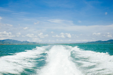 Wave from speed boat on the sea and blue sky white cloud