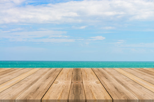 Vintage wooden board empty table in front of blue sea & sky background. Perspective wood floor over sea and sky - can be used for display or montage your products. beach & summer concepts.