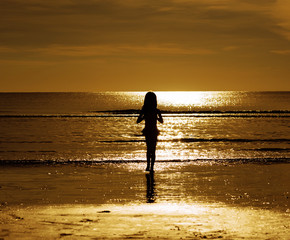 Fototapeta premium Silhouette style little girl on the beach
