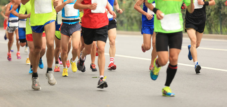 Many marathon runners running on city road