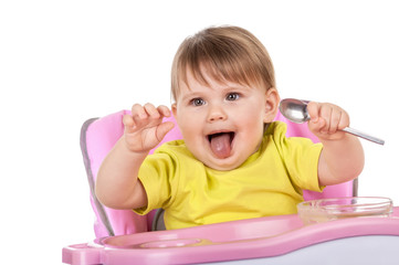 Funny baby girl is sitting in his chair