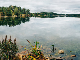 Beautiful autumn landscape, the lake with reflections and boats