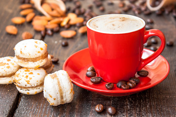 Red cup of coffee and macaroons