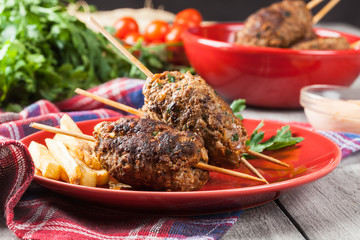 Barbecued kofta with fries on a plate