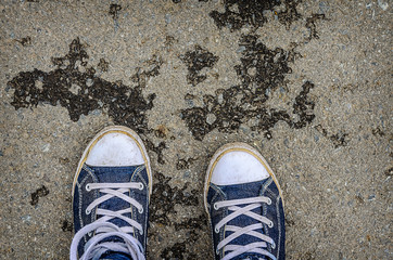 Blue sneakers shoes walking on concrete top view. 