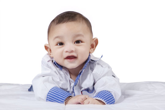 Attractive male infant laughing on bed