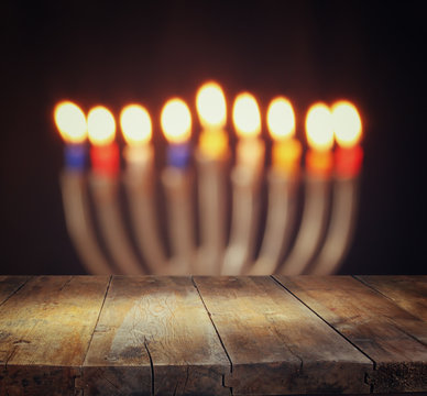 Image of jewish holiday Hanukkah background with menorah (traditional candelabra) Burning candles and wooden table
