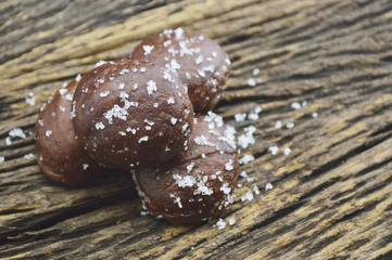 Small chocolate doughnuts on old wooden background