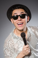 Young man in silver shirt and microphone isolated on white