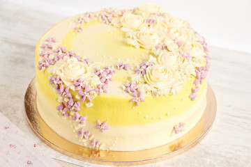 Obraz na płótnie Canvas Yellow cake with cream flowers