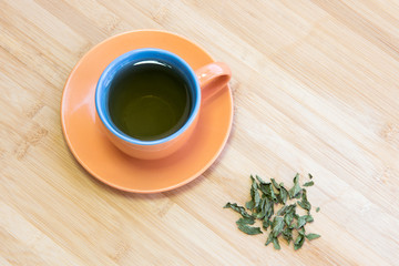 Cup of healthy green tea with leaves
