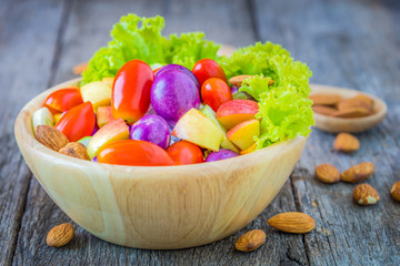 Fresh vegetable salad on wooden background.