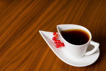 coffee cup with viburnum on brown table
