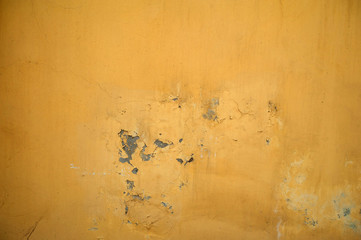 Texture of old wall covered with yellow stucco