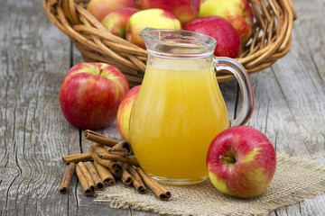 Apple juice and apples on wooden background