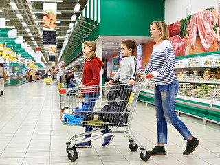 Happy women and children with cart shopping