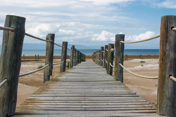 Wooden bridge on sandy beach of the Mediterranean see
