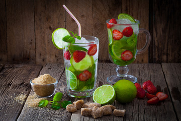Fresh mojito cocktail with strawberry on a wooden table