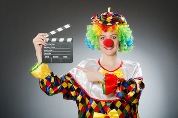 Clown with movie clapper in funny concept